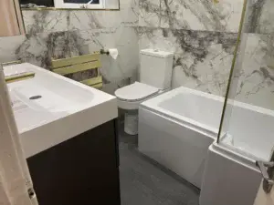 Bathroom fit with gold fittings and marble tiles image